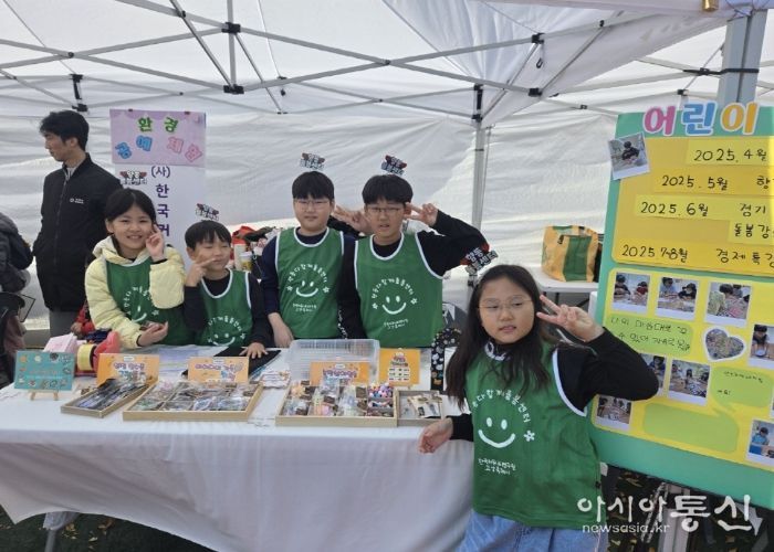 아동창업팀 수공예품 판매 부스에서 아이들이 포즈를 취하고 있다.