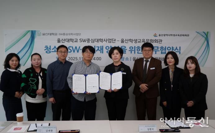 울산학생교육문화회관 김현미 관장(오른쪽)과 김대환 울산대학교 성과확산센터장이 업무협약을 체결하고 기념사진을 찍고있다