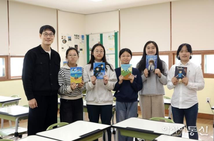 독서토론 동아리 학생들이 22일 자신이 출간한 책을 들고 기념사진을 찍고있다.