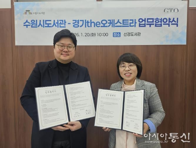 최현주 수원시도서관사업소장(오른쪽)과 허석환 경기더(the)오케스트라 관계자가 협약 후 기념촬영을 하고 있다.